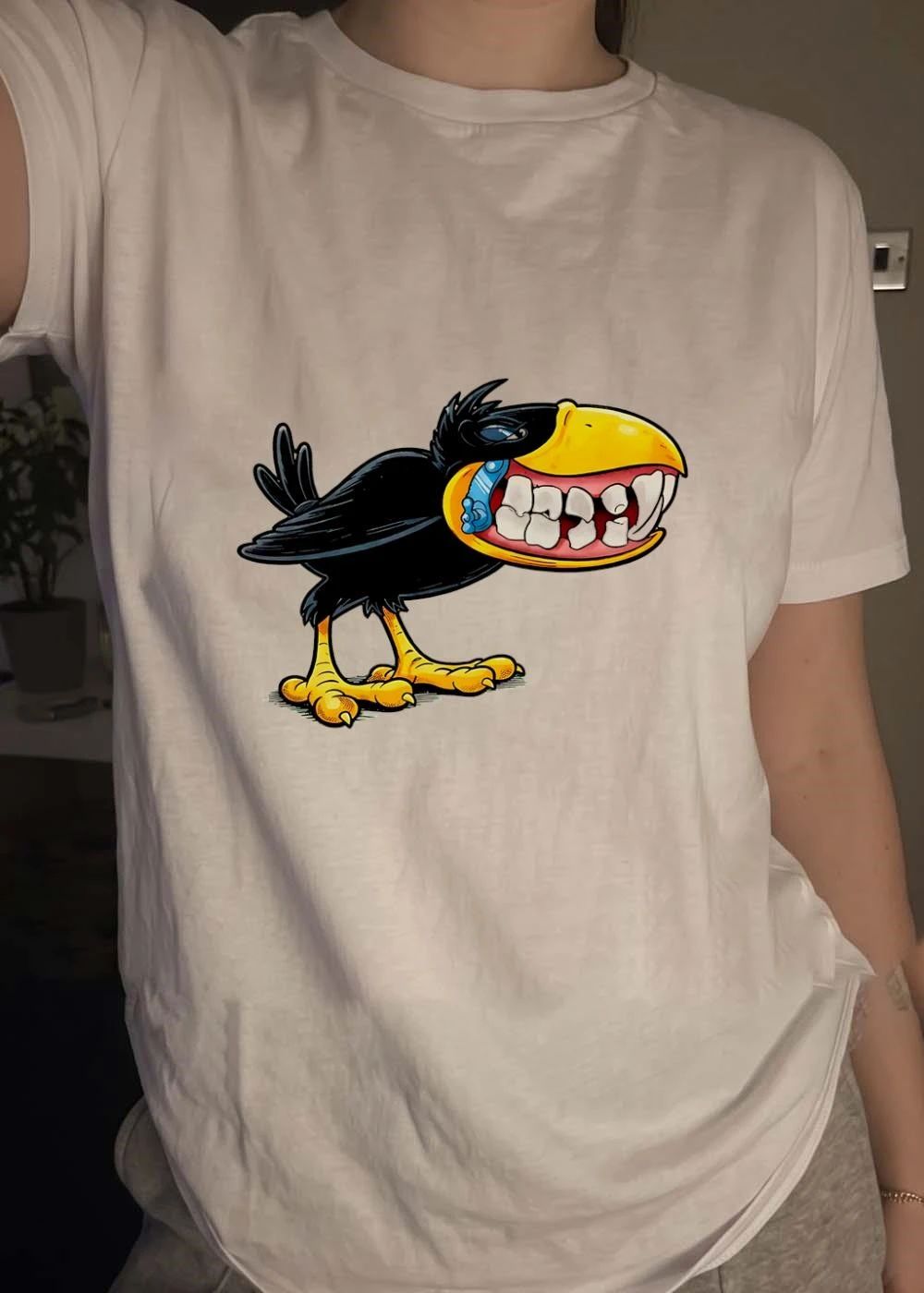 Crow with Teeth and Blue Phone Cartoon Graphic Green Background T-Shirt